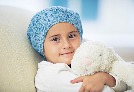 child hugging a stuffed toy in a hospital bed