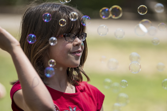 girl playing with bubbles
