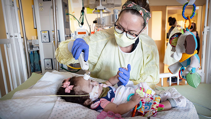 Nurse in UC Davis Pediatric Intensive Care Unit taking care of young patient