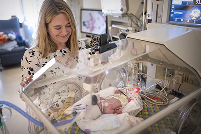 Kristin Hoffman, M.D., checking in on neonatal infant in nursery