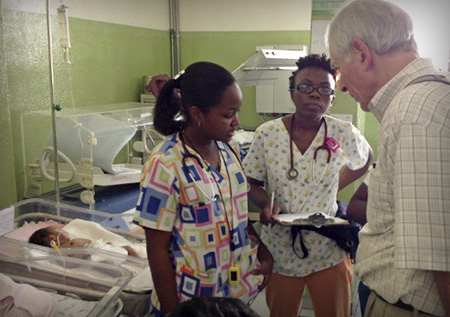 Global health doctor with two patients in neonatal ward.