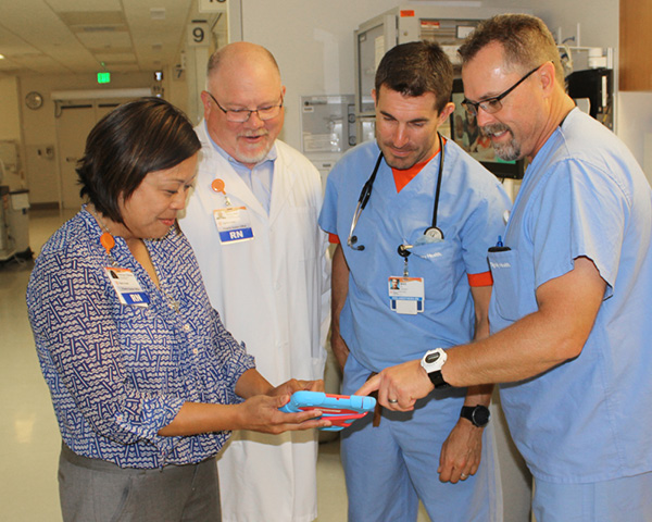 Frances Patmon, left, and Perry Gee, center left, discuss research with nurses at Dignity Health Mercy Medical Center Redding. Courtesy of Dignity Health Mercy Medical Center Redding