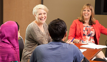 Master’s-degree leadership alumni Andrea Rosato, left, and Beverly Schacherbauer host a health training they developed in their Community Connections coursework with an Afghani family.