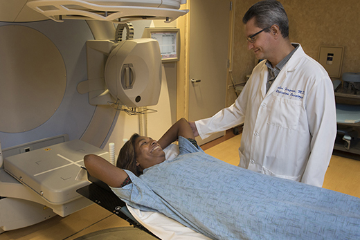 A female patient smiling at a male doctor before receiving radiation