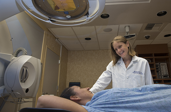 A female doctor smiling down at a patient before radiation