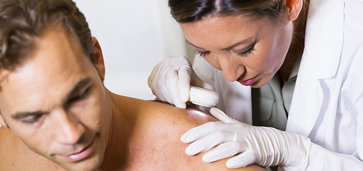  Dermatologist examining skin of a patient