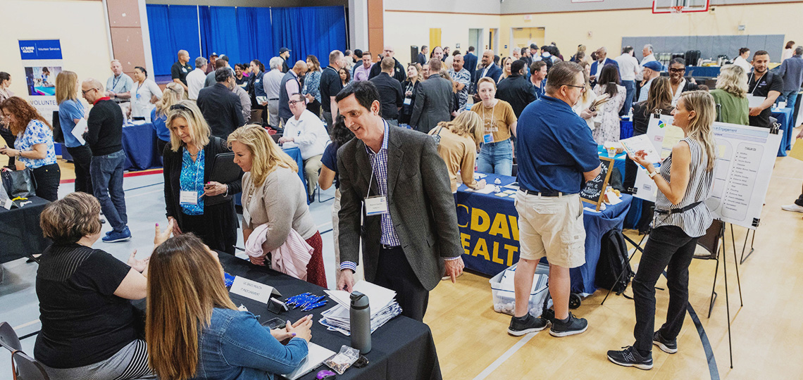 : Dozens of people converge in a community center gymnasium at the 2024 Small and Diverse Supplier Expo