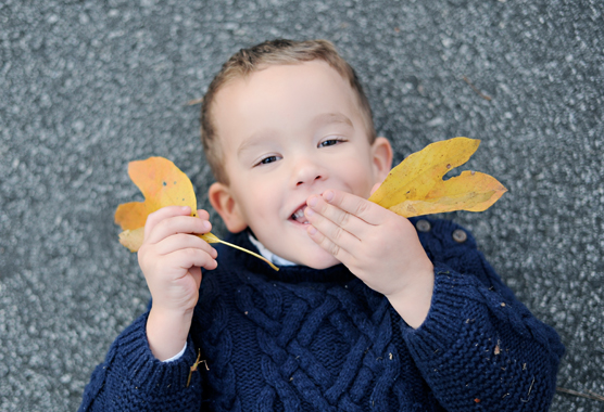 boy playing with leaves