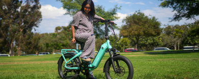 a woman getting on an electric bicycle